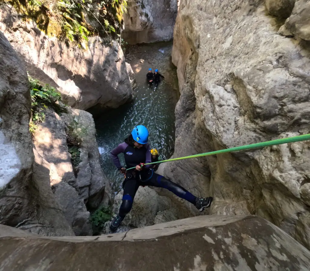 Una noia baixant en ràpel per les imponents parets de roca del barranc de l'Infern, a l'estret de Collegats, Pallars Sobirà.